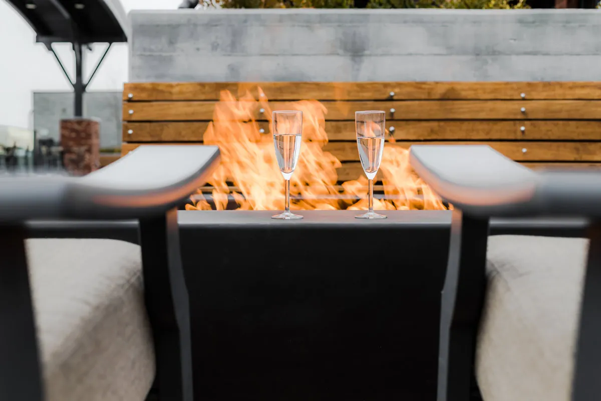 Fire feature on the rooftop deck with two champagne flutes at the edge