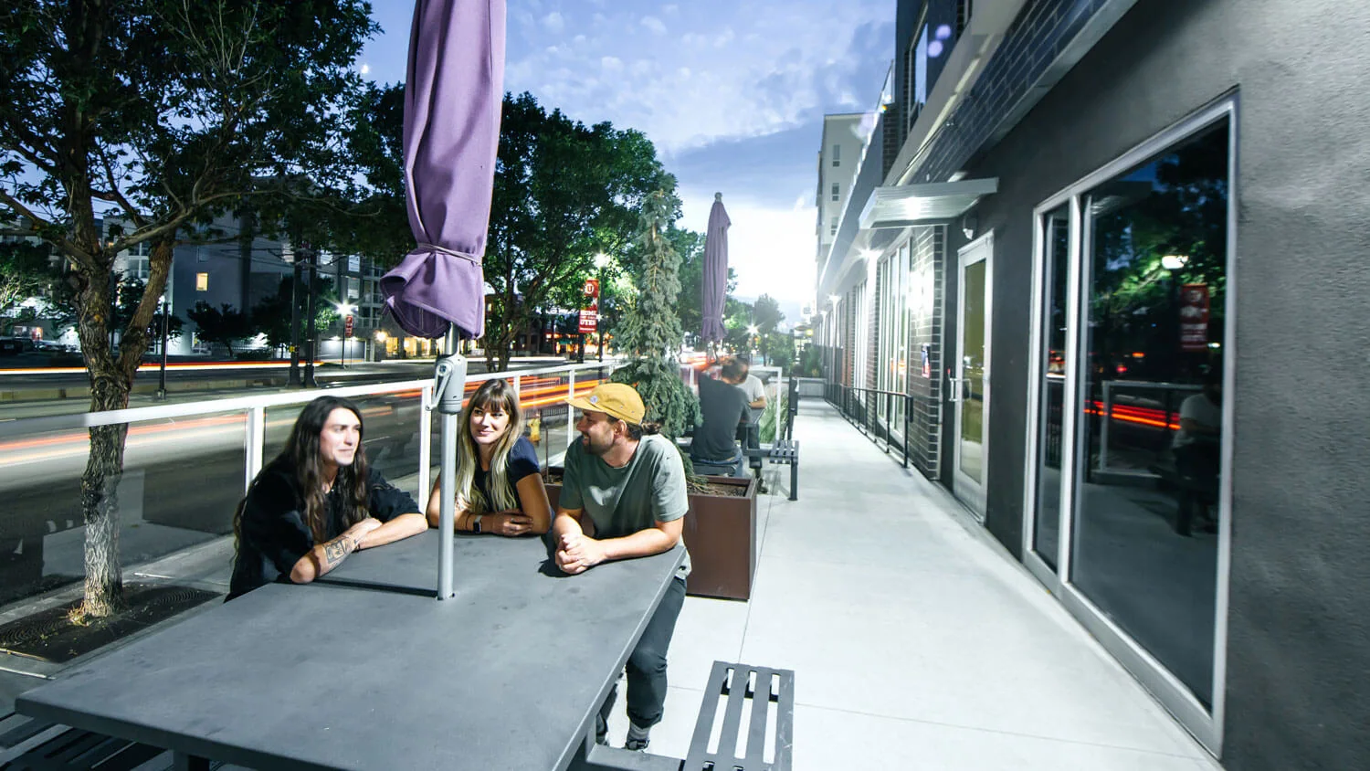friends socializing at a table on an urban street side patio