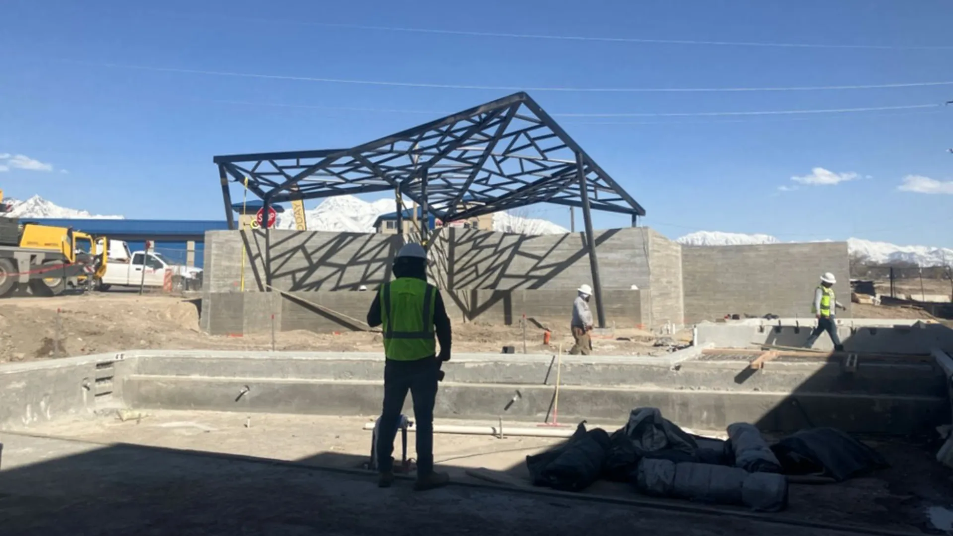 Install crew under the Embold shade structure with mountains beyond