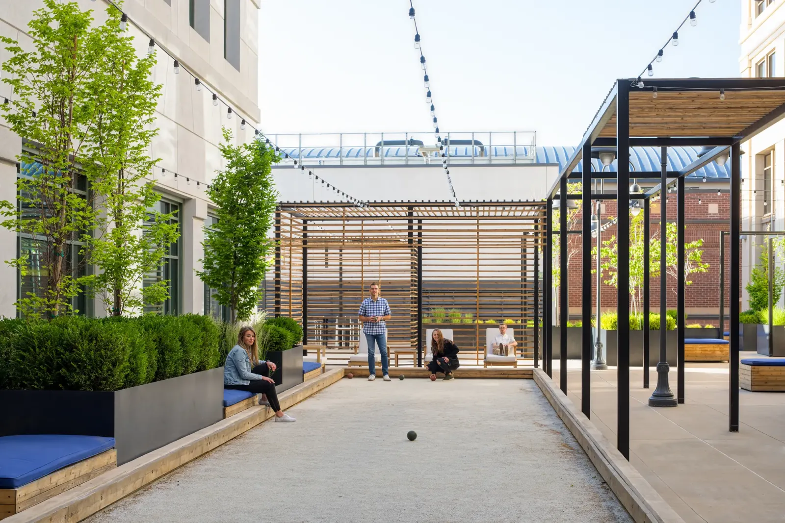 Hidden Gem finished rooftop office-patio amenity at The Gateway, the bocce court and pergolas between the towers