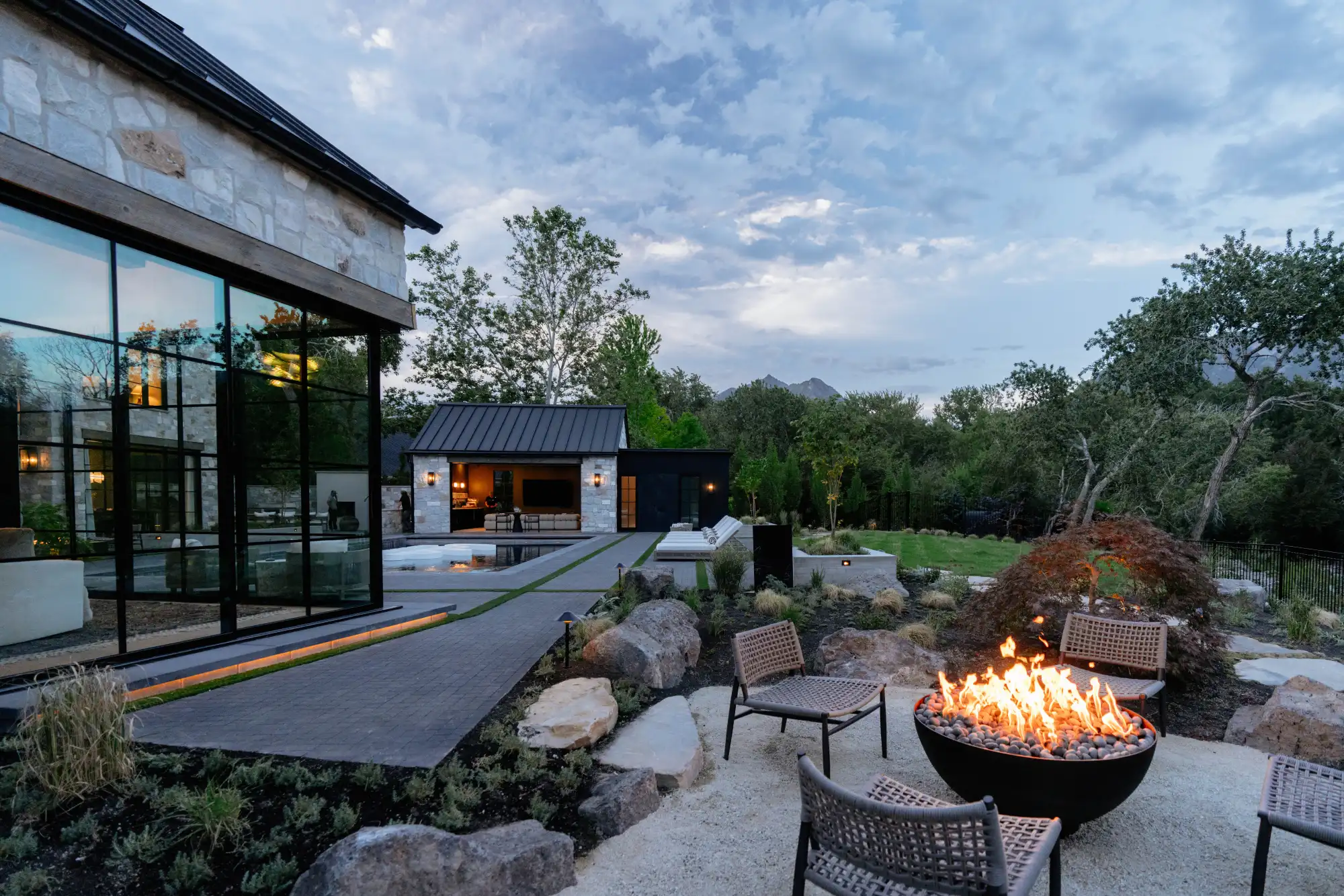 The fire bowl on the gravel court, the paved path to the pool house and the mountains beyond