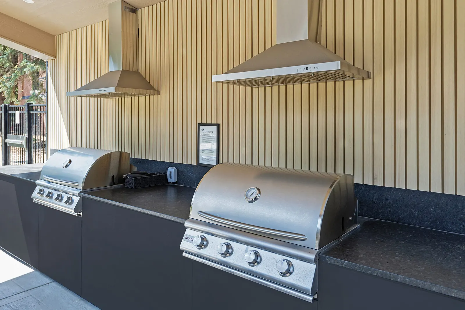 Two grills under range hoods in the covered outdoor kitchen