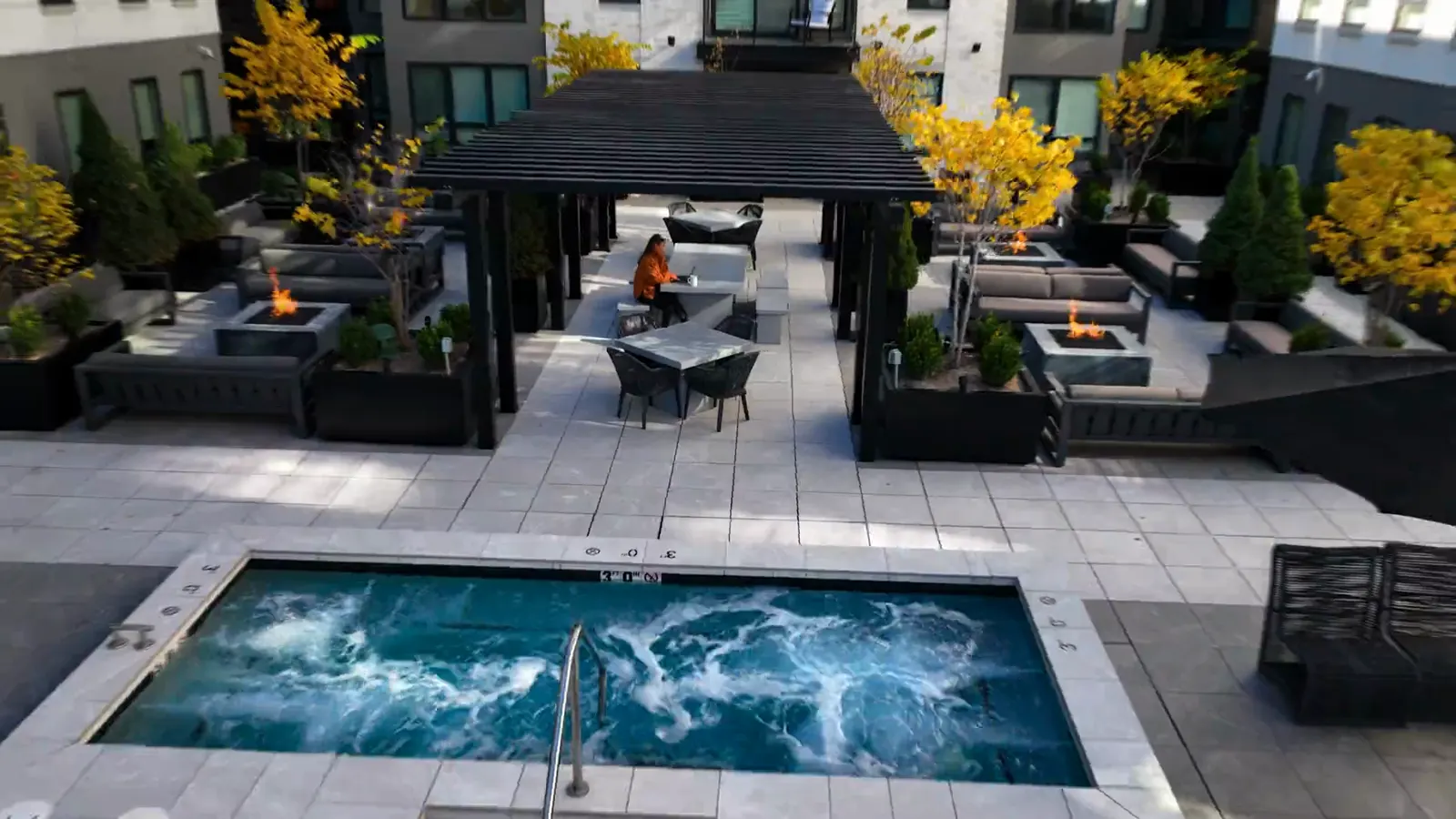 The Sugar Alley rooftop at golden hour, fire tables and pergola above the spa